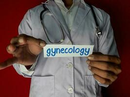 A doctor standing, Hold the gynecology paper text on red background. Medical and healthcare concept. photo