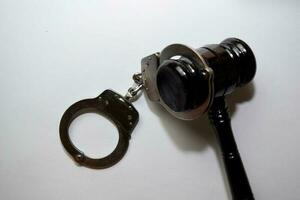 handcuffs and black gavel isolated on white background. Justice and law concept photo