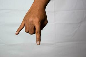 Close up Asian man shows hand gestures it means Horns isolated on white background photo