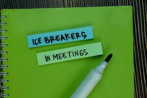 Ice Breakers in Meetings write on sticky notes isolated on Wooden Table. photo