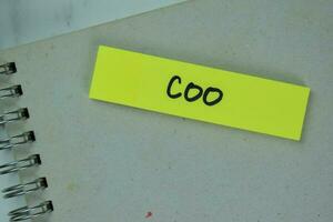 COO - Chief Operating Officer write on sticky notes isolated on Wooden Table. photo