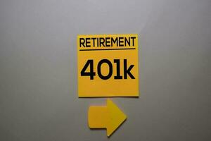 Retirement 401k write on a sticky note isolated on office desk. photo