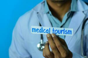 Doctor holding a card with text medical tourism. Medical and healthcare concept. photo