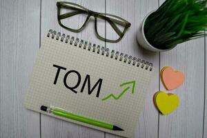 TQM - Total Equality Management write on a book isolated on Office Desk. photo