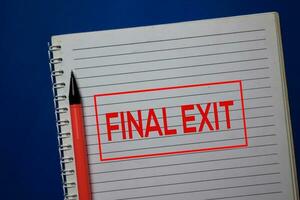 Final Exit write on a book isolated on blue background. photo