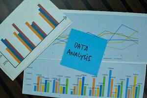 Data analysis write on sticky notes isolated on Wooden Table. photo