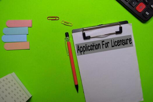 Application for Licensure write on a paperwork isolated on Office Desk photo