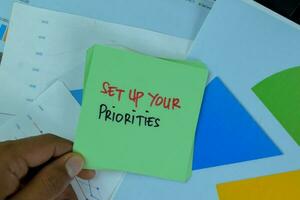 Set Up Your Priorities write on sticky notes isolated on Wooden Table. photo