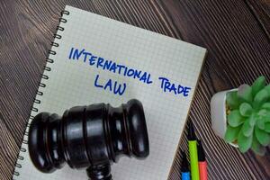 International Trade Law write on a book isolated on Wooden Table. photo