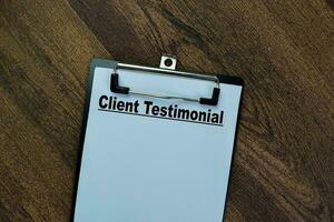 Concept of Client Testimonial write on paperwork isolated on Wooden Table. photo