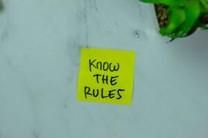 Concept of Know The Rules write on sticky notes isolated on Wooden Table. photo