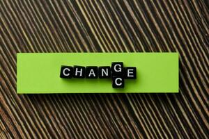 Change into Change on wooden block isolated on wooden table photo