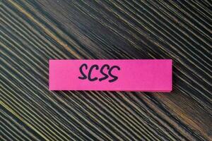 SCSS write on sticky notes isolated on Wooden Table. photo