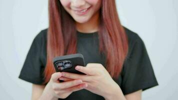 teknologi begrepp leende asiatisk flicka använder sig av smartphone textning på mobil telefon stående lutande video