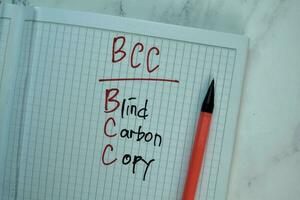 BCC - Blind Carbon Copy write on a book isolated on Wooden Table. photo