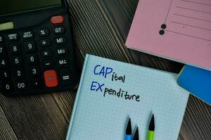 Capital Expenditure write on a book isolated on office desk. photo