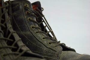 Close up of a brown old boots isolated on white background photo