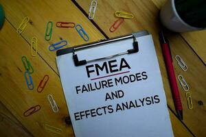 FMEA - Failure Modes and Effects Analysis write on a paperwork isolated on wooden background. photo