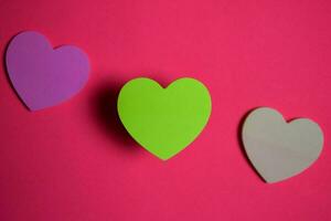 sticky note shaped a heart symbol on pink background photo