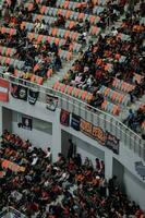 multitudes en grupo de aficionados en el estadio Jacarta internacional estadio. selectivo atención en bandera. Jacarta, Indonesia, agosto 1, 2022 foto