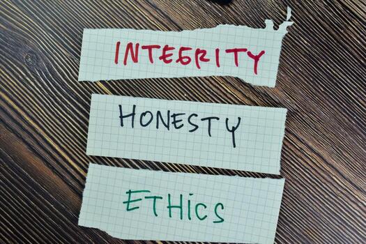 Concept of Integrity, Honesty and Ethics write on sticky notes isolated on Wooden Table. photo