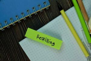 Reskilling text on sticky notes with office desk. photo