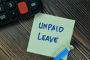 Unpaid Leave write on sticky notes isolated on Wooden Table. photo