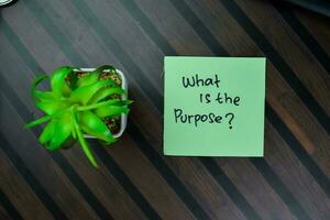 Concept of What is the Purpose write on sticky notes isolated on Wooden Table. photo