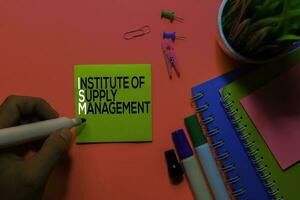 ISM. Institute of Supply Management acronym on sticky notes. Office desk background photo