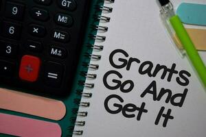 Grants Go and Get It write on a book isolated on Office Desk photo
