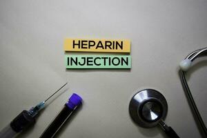 Heparin Injection text on Sticky Notes. Top view isolated on office desk. Healthcare Medical concept photo