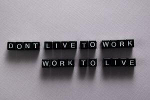 Don't live to work. Work to live on wooden blocks. Motivation and inspiration concept photo
