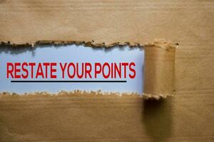 Restate Your Points Text written in torn paper photo