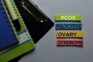 PCOS. Polycystic Ovary Syndrome write on sticky notes. Isolated on white table background photo