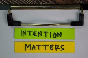 Intention Matters write on sticky notes isolated on Wooden Table. photo