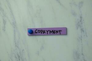 Copayment write on sticky notes isolated on office desk. photo