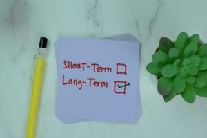 Concept of Long-Term write on a book isolated on Wooden Table. photo
