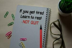 If you get tired. Learn to rest NOT QUIT write on a book isolated on Office Desk photo