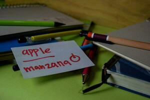 Manzana write on a sticky note isolated on Office Desk. Learning Spanish Language concept photo