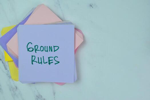 Concept of Ground Rules write on sticky notes isolated on Wooden Table. photo