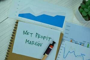 Concept of Net Profit Margin write on sticky notes isolated on Wooden Table. photo