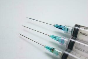 Close up of a syringe selective focus on needle, isolated on white background photo