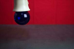 Close up lamp in red background and black table photo