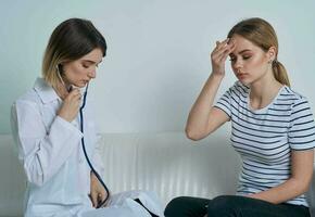 Woman doctor with stethoscope and patient at the reception photo