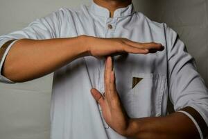 Close up Asian man shows hand gestures it means time out isolated on white background photo