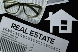 Real Estate text in headline isolated on black background. Newspaper concept photo