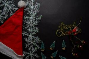 Santa Claus red hat, merry christmas text and Decorative Christmas gifts isolated on black background photo