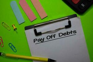 Pay Off Debts write on a paperwork isolated on Office Desk photo