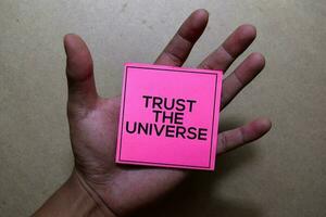 Trust the Universe write on Book. Isolated on office desk background photo