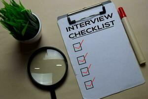 Interview Checlist write on a paperwork isolated on office desk. photo